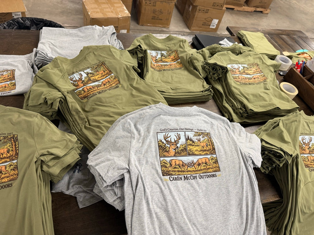 Stacks of olive and gray Cardin McCoy graphic T-shirts from a brand print run.